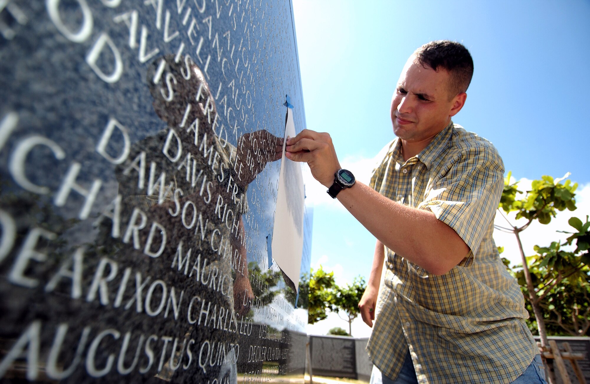 Tech. Sgt. Victor Follis does a pencil rubbing July 15 of the name of a servicemember who died in the Battle of Okinawa. Sergeant Follis does the rubbings to help family members to remain connected to their loved ones who died in the battle more than 60 years ago. The memorial is located in Peace Prayer Park in Itoman City, Japan. Sergeant Follis is with the 18th Maintenance Group at Kadena Air Base, Japan. (U.S. Air Force photo/Tech. Sgt. Rey Ramon)       