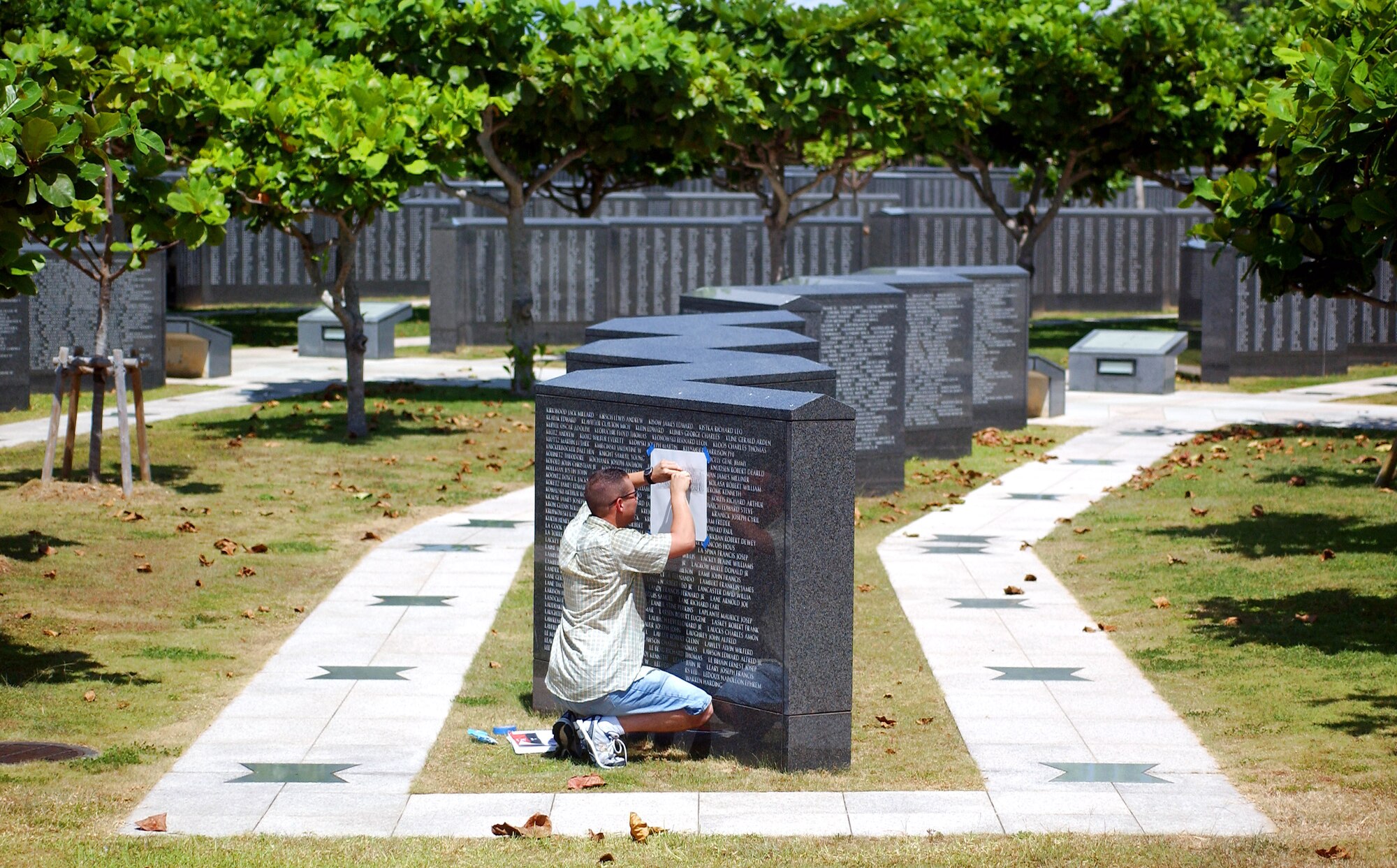 Tech. Sgt. Victor Follis does a pencil rubbing July 15 of the name of a servicemember who died in the Battle of Okinawa. Sergeant Follis does the rubbings to help family members to remain connected to their loved ones who died in the battle more than 60 years ago. The memorial is located in Peace Prayer Park in Itoman City, Japan. Sergeant Follis is with the 18th Maintenance Group at Kadena Air Base, Japan. (U.S. Air Force photo/Tech. Sgt. Rey Ramon)        