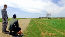 MINOT AIR FORCE BASE, N.D. – Staff Sgt. Michael Burnett, 5th Civil Engineer Squadron Explosive Ordinance Disposal journeyman, assists Cadet 3rd Class Andrew Buttitta as he pulls the trigger on the composition four explosive device the team set up at the EOD training grounds July 10 here. The training was part of their ongoing Operation Air Force Third Lieutenant course. (U.S. Air Force photo by Airman 1st Class Benjamin Stratton)
