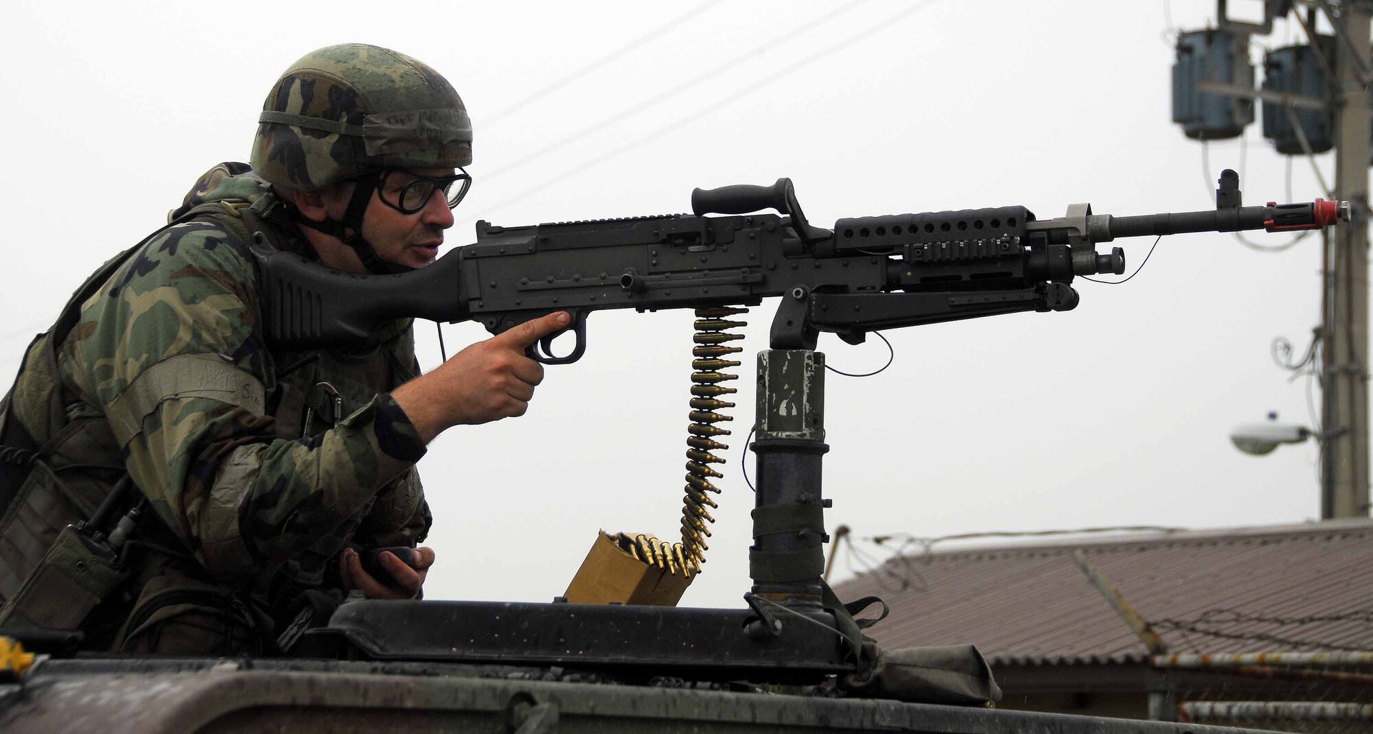OSAN AIR BASE, Republic of Korea -- Tech. Sgt. Michael McCaghren, 51st Security Forces Squadron, aims his mounted weapon during an exercise here July 23. Sergeant McCaghren was searching the area for opposing forces. The week-long operational readiness exercise tests Team Osan's ability to execute combat operations, receive follow-on forces and defend the base from attack. (U.S. Air Force photo/Senior Airman Christopher Boitz)