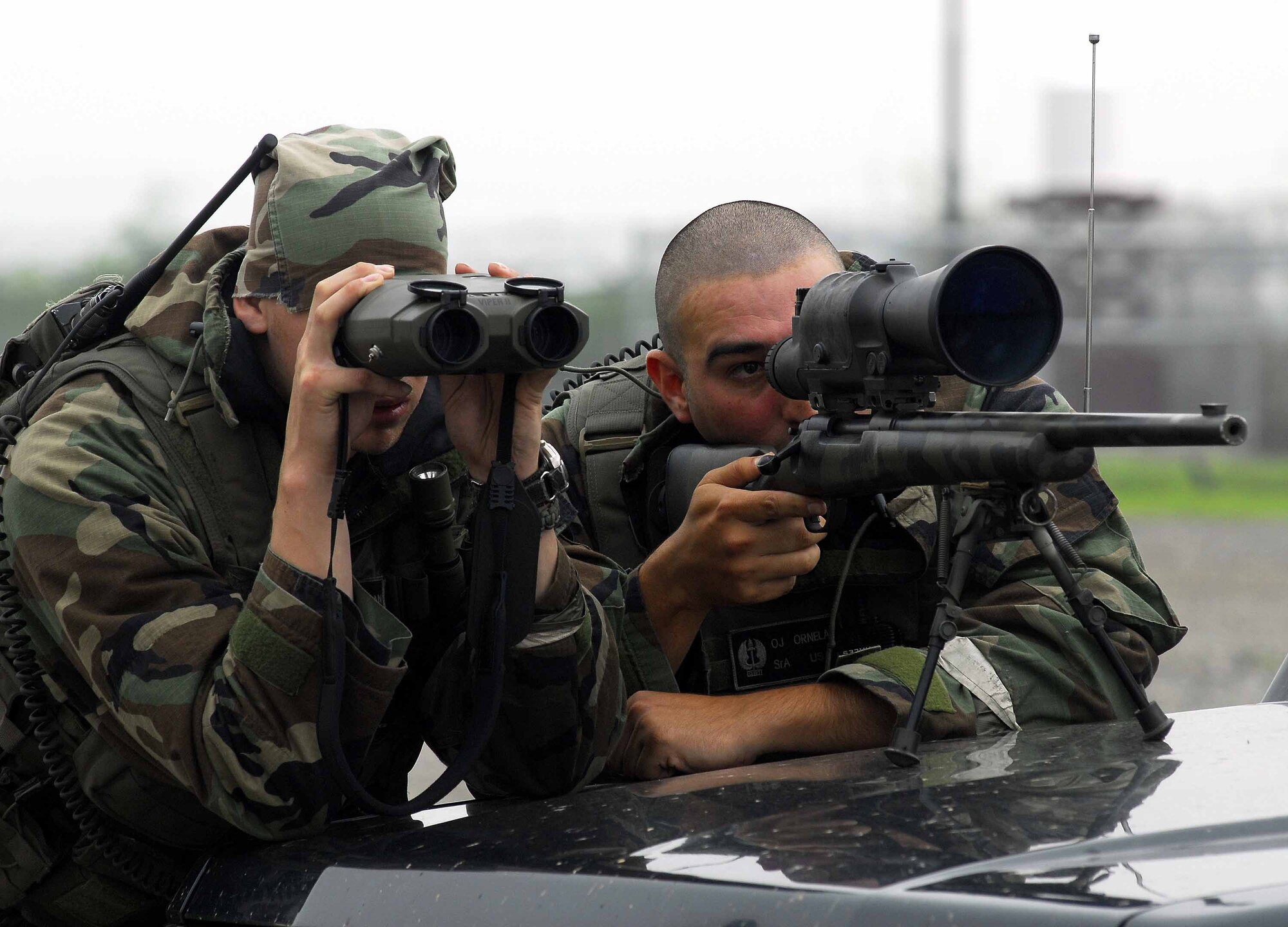 OSAN AIR BASE, Republic of Korea – Senior Airman Nathan Patterson, (left), and Senior Airman Inez Ornelas, a 51st Security Forces Squadron sniper team, search for opposing forces during a base-wide exercise here July 23. The 51st SFS Defenders play a key role in securing the base during training and real world situations. (U.S. Air Force photo by Senior Airman Christopher Boitz)