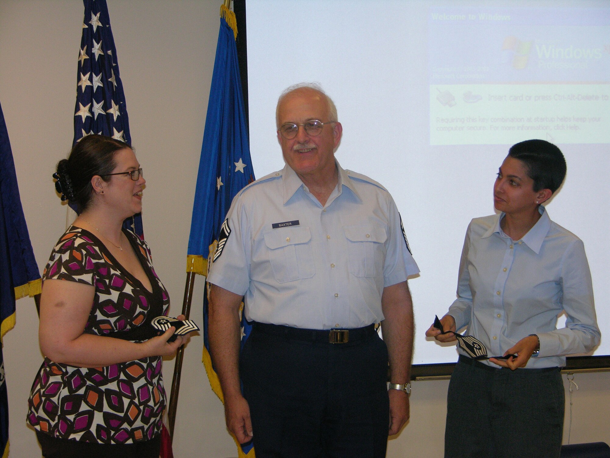John "Jack" Baxter prepares to have his Chief Master Sergeant rank tacked on by his daughters, Kristen Clark and Jennifer Baxter, during his promotion ceremony July 12th. He will assume the title of 152nd AOG Communications superintendent later this summer. (Photo by Master Sgt. Brenda Shepard, 152nd AOG)
