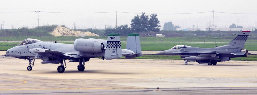 OSAN AIR BASE, Republic of Korea -- An A-10 Thunderbolt II, assigned to the 25th Fighter Squadron, and an F-16 assigned to the 36th Fighter Squadron, prepare to launch during Exercise Beverly Bulldog 08-03 here July 23. The week-long operational readiness exercise tests Team Osan's ability to execute combat operations, receive follow-on forces and defend the base from attack. (U.S. Air Force photo/Senior Airman Christopher Boitz)
