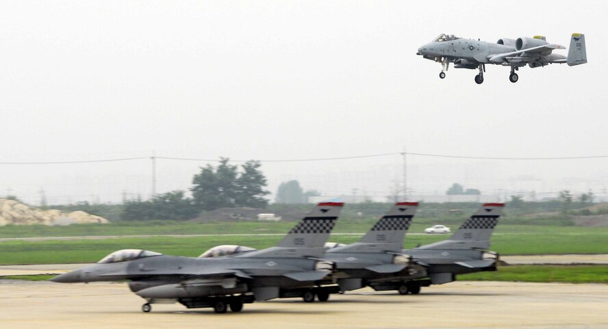 OSAN AIR BASE, Republic of Korea -- An A-10 Thunderbolt II, assigned to the 25th Fighter Squadron, comes in for a landing, as three F-16 Fighting Falcons from the 36th Fighter Squadron wait to launch during a base-wide exercise here July 23. (U.S. Air Force photo/Senior Airman Christopher Boitz)