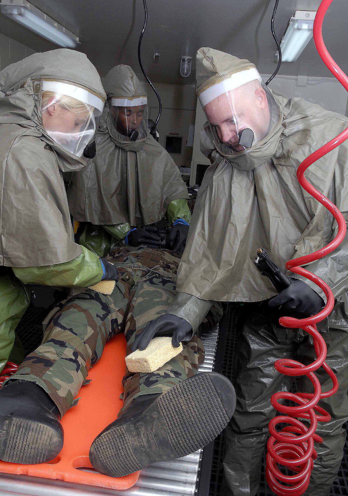 OSAN AIR BASE, Republic of Korea -- Members of the 51st Medical Group decontamination team scrub down an "injured" Airman after a simulated chemical attack exercise Beverly Bulldog 08-03 here July 22. The hard-sheltered, in-place decontamination facility is the only one of its kind in the entire Air Force. (U.S. Air Force photo/Staff Sgt. Scottie McCord)