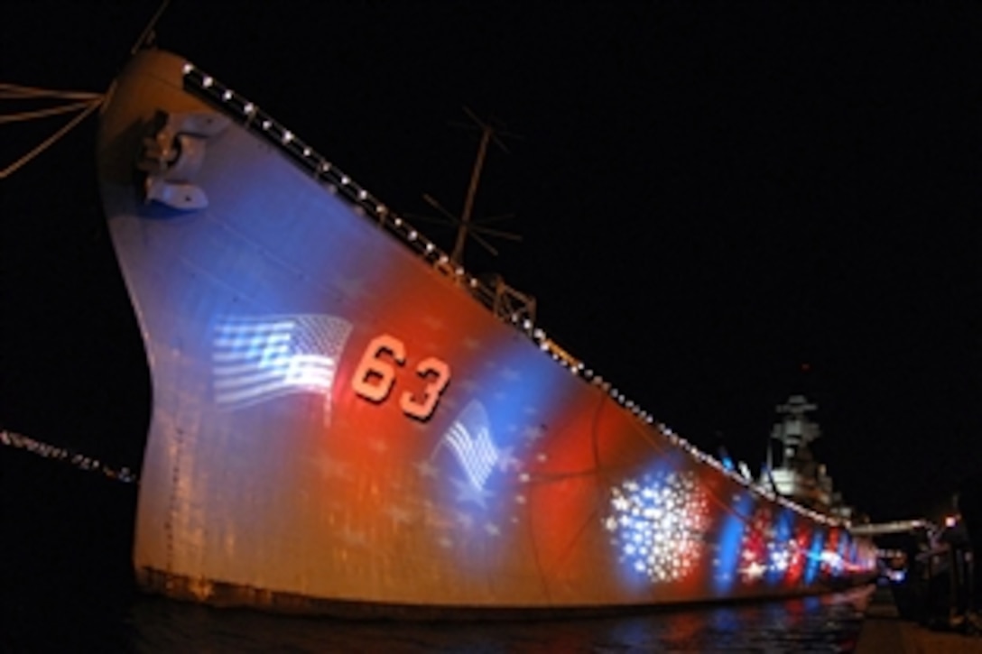 Red, white and blue lights illuminate the Battleship Missouri Memorial for the Navy's Great White Gala at Pearl Harbor, July 18, 2007. The ceremony, which marked the centennial anniversary of the Great White Fleets arrival to Hawaii, included a pass and review by the guided-missile destroyer USS Chafee and the guided-missile frigate USS Crommelin, and a fly-by of four F/A-18 Super Hornets from the aircraft carrier USS Kitty Hawk.