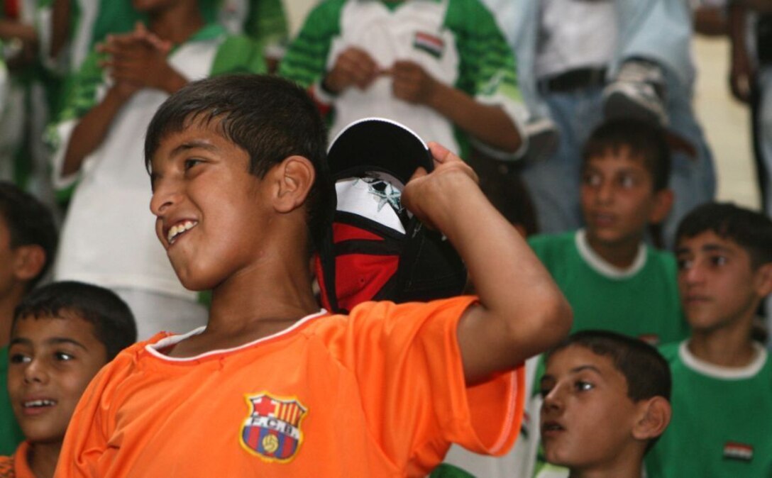 RAMADI, Iraq (July 23, 2008) - An Iraqi boy cheers on his neighborhood's soccer team during the Ramadi Youth Conference soccer tournament July 23. “Education and sports go hand-in-hand in a kids’ learning process,” said Air Force Col. Ante-Amburgey, the embedded public relations team leader for Ramadi.  “It’s important for the kids to know that there are youth activities available to them during the summer months when schools are not in session.” (Official U.S. Marine Corps photo by Lance Cpl. Casey Jones) (RELEASED)