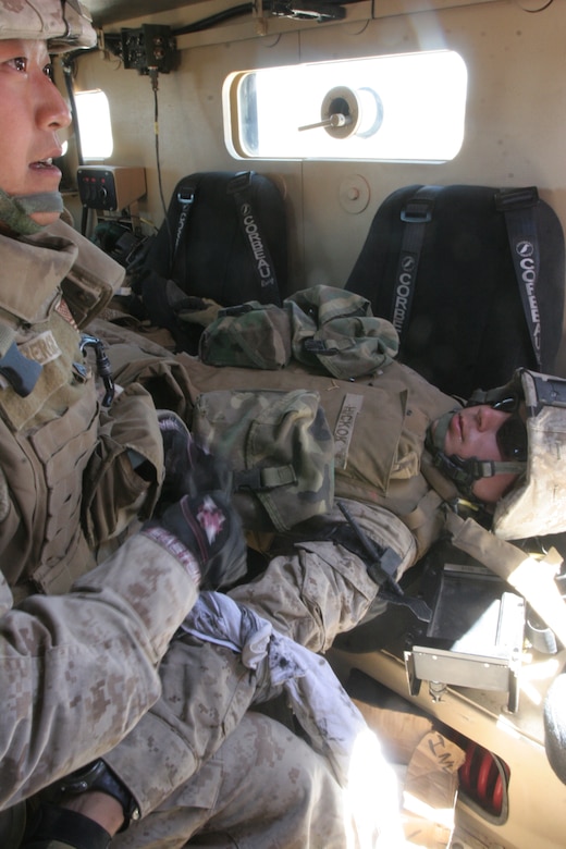 Cpl. Jesse Weinberger, combat engineer, 1st Combat Engineer Battalion, 1st Marine Division, Marine Corps Base Camp Pendleton, Calif., applies a tourniquet to Pfc. Mark Hickok, combat engineer, 1st CEB, at the Combat Center’s live-fire convoy course July 24. Weinberger and Hickok were taking part in Summer Heat, a semi-annual pre-deployment training exercise sponsored by 1st Tanks Battalion.