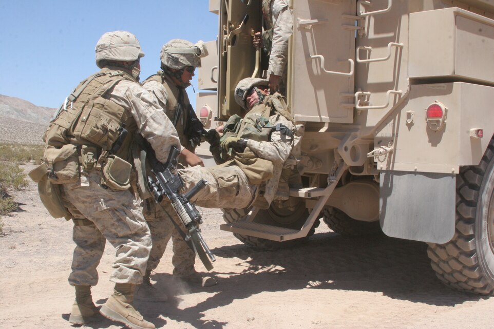 Marines with 1st Combat Engineer Battalion, 1st Marine Division, Marine Corps Base Camp Pendleton, Calif., practice moving an injured team member at the Combat Center’s live-fire convoy course July 24. The Marines were giving a scenario where their vehicle had been hit by an improvised explosive device, forcing them to apply medical aid to their comrade and prepare him for aerial transport out of the area.