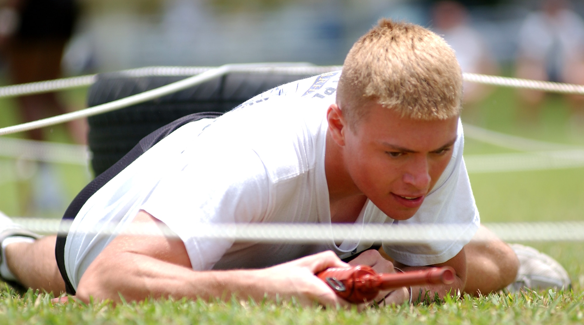 Airman Daniel Shimanski, 18th Aerospace Medicine Squadron, low crawls through an obstacle course with a mock rifle during the 2008 Joint Service Fitness Challenge held at Kadena Air Base July 18. The event pitted 26 teams from various military branches against one another in an attempt to claim fitness supremacy. At the end of the day, Kadena’s own 31st Rescue Squadron walked away with the first and second place trophies and the opportunity to defend their title next year. (U.S. Air Force photo/Senior Airman Nestor Cruz) 