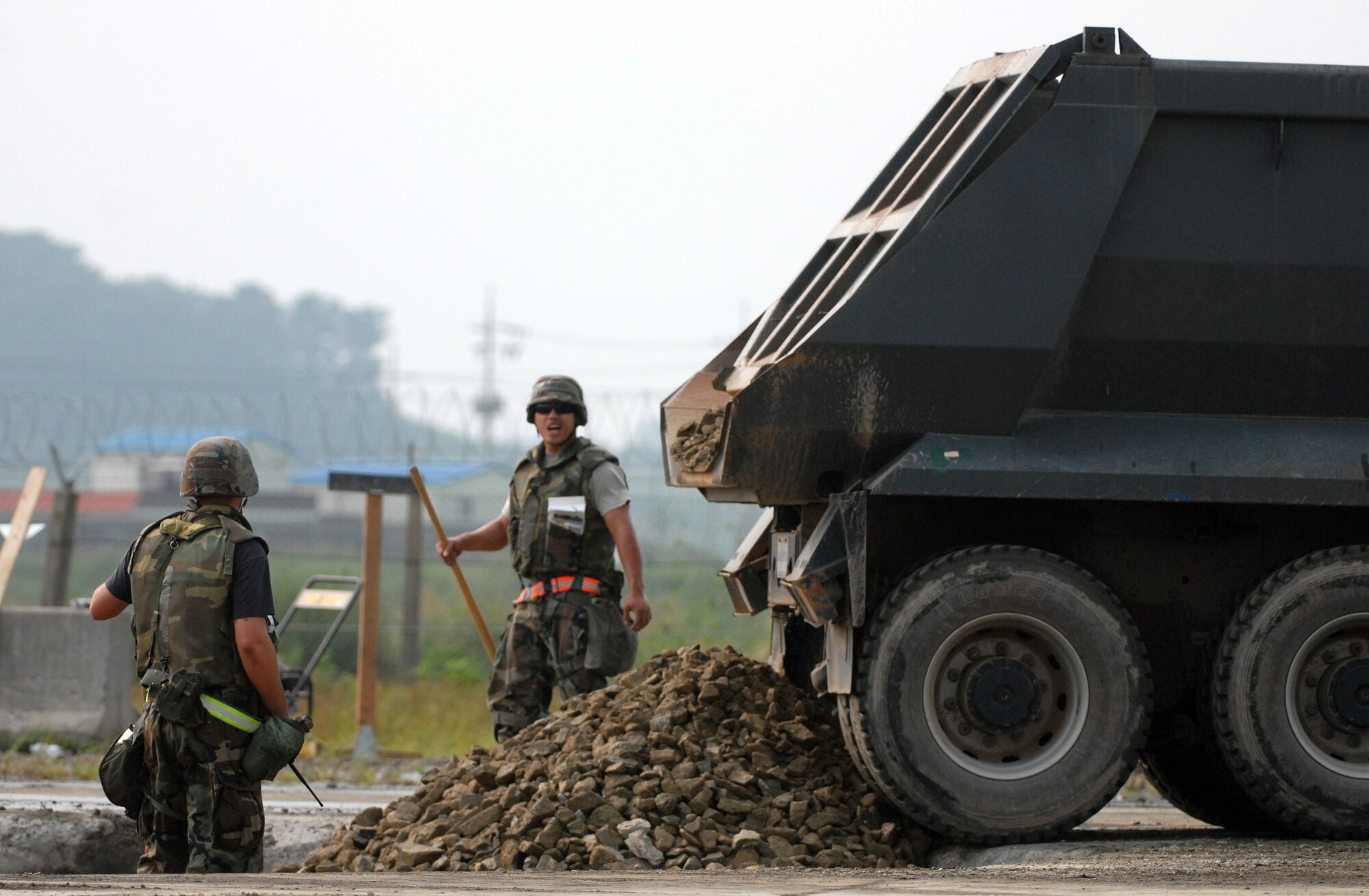 KUNSAN AIR BASE, Republic of Korea -- Staff Sgt. Vincent Vargas and Airman First Class David Kim, members of the 8th Civil Engineer Squadron Rapid Runway Repair team work to restore the runway during a peninsula wide operational readiness exercise scenario here July 24.  Kunsan is participating the PENORE to evaluate the wing’s readiness and ability to perform its wartime mission.  (U.S. Air Force photo/TSgt Quinton T. Burris)