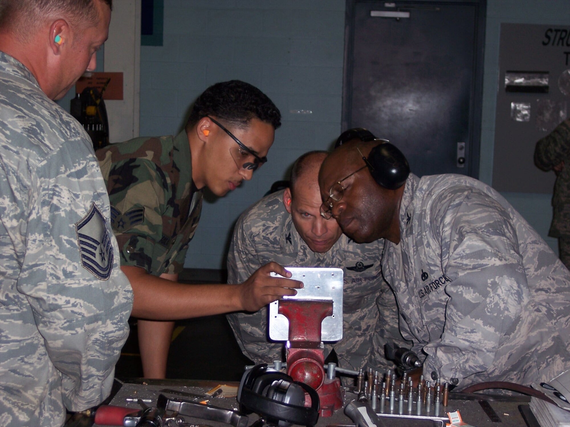 MCCONNELL AIR FORCE BASE, Kan. -- Master Sgt. Henry Burns and Senior Airman Miguel Verdejo, 22nd Maintenance Squadron, structural maintenance, evaluates the installation of solid rivets placed by Col. James C. Vechery, 22nd Air Refueling Wing commander, and Col. Michael Dillard, 22nd Maintenance Group commander. Structural maintenance is responsible for repairs and replacing structural assemblies on all assigned aircraft at McConnell. (Photo by Staff Sgt. James Lucas)