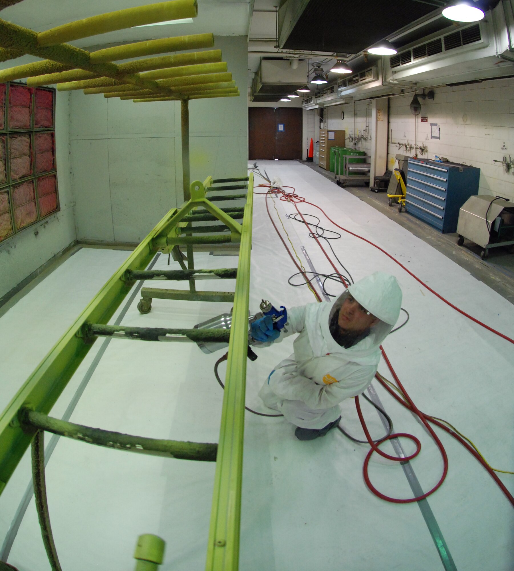 MCCONNELL AIR FORCE BASE, Kan. -- Airman 1st Class Joseph Bromley, 22 Maintenance Squadron, corrosion prevention, prepares to prime an aircraft crew entry latter before it is painted. (photo by Airman 1st Class Jessica Lockoski)