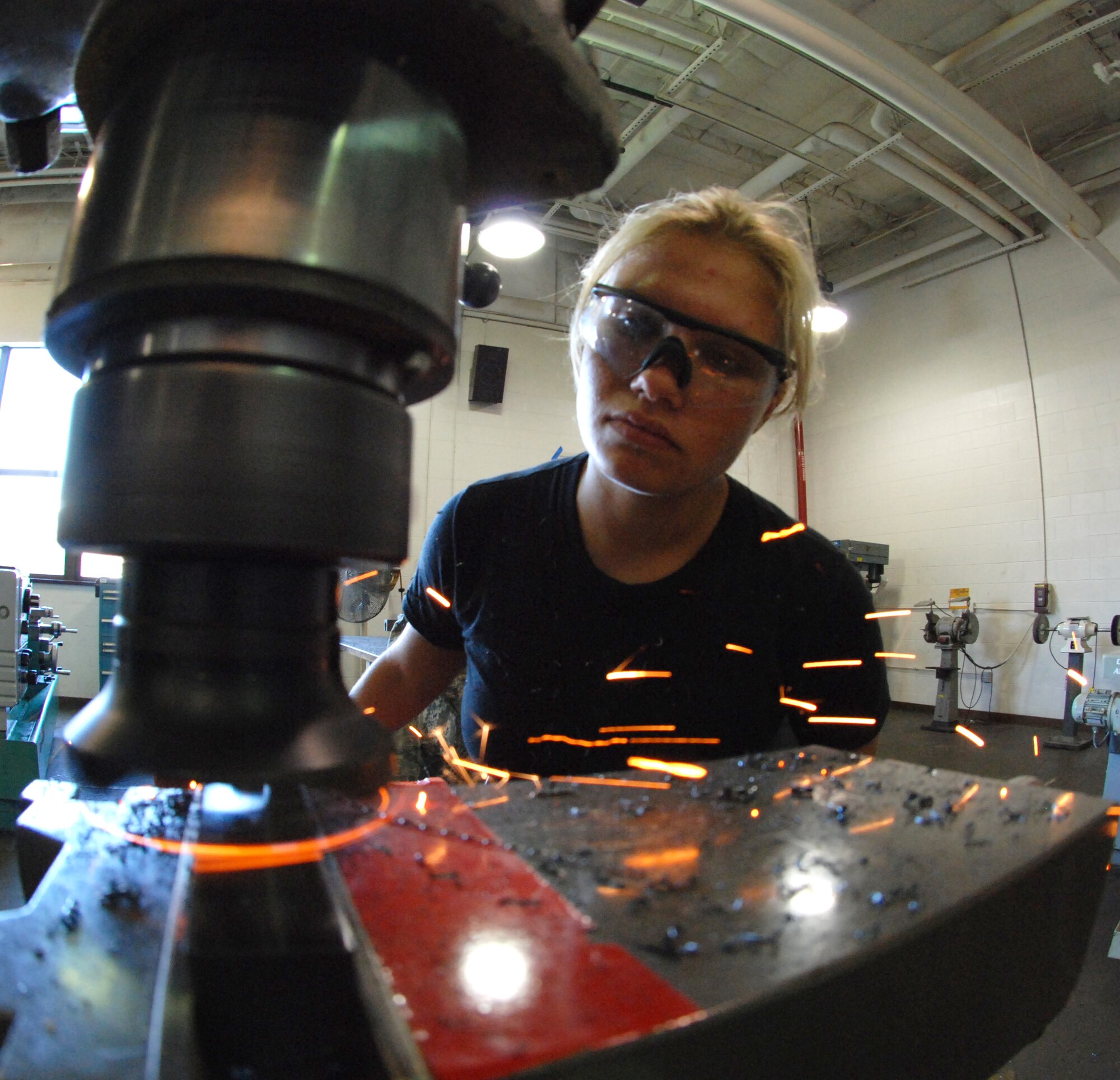 MCCONNELL AIR FORCE BASE, Kan. -- Airman 1st Class Christine Desrochers, 22nd Maintenance Squadron metals technician, manufactures a lathe tool on a milling machine, July 24. The metals technology squadron also checks components for wear tolerances using precision measuring devices as well as maintains and routinely inspects all machinery. (photo by Airman 1st Class Jessica Lockoski)