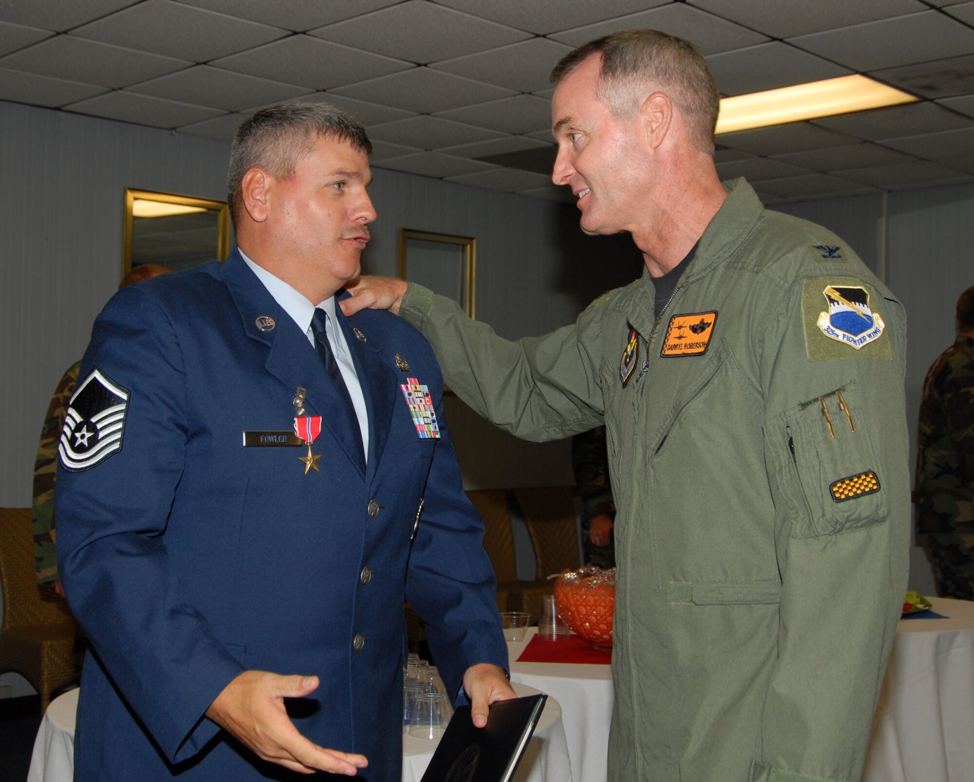Col. Darryl Roberson, 325th Fighter Wing commander, congratulates Master Sgt. Michael Fowler, 325th Civil Engineer Squadron fire protection specialist, for earning the Bronze Star Medal for meritorious achievement during his time in Afghanistan.  (US Air Force photo by Susan Trahan) 

