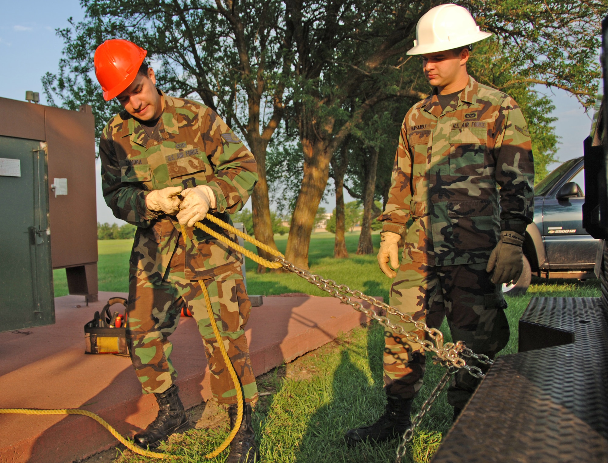 Airman Basic Brad Vanzandt (right), a Reservist assigned to the 931st Civil Engineer Squadron, watches Staff Sgt. Michael Zamora prepare a chain and rope for pulling out underground wires near the main gate at McConnell Air Force Base, Kan. An Force Reserve program is providing funds for Airman Vanzandt to train with Sergeant Zamora and other active-duty engineers at McConnell. The program is designed to speed up the training of traditional Reservists beyond what one weekend a month and a few weeks a year usually allows. (U.S. Air Force photo/Tech. Sgt. Jason Schaap)