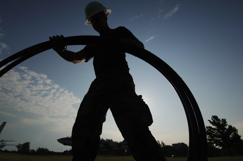 Airman Basic Brad Vanzandt, a Reservist assigned to the 931st Civil Engineer Squadron, rolls up electrical tubing pulled from under the ground near the main gate at McConnell Air Force Base, Kan. Air Force Reserve Command's Seasoning Training Program made it possible for Airman Vanzandt to train full-time with engineers assigned to the 931st's active-duty host unitat McConnell, the 22nd Air Refueling Wing. The program is designed to speed up the training of traditional Reservists beyond what one weekend a month and a few weeks a year usually allows. (U.S. Air Force photo/Tech. Sgt. Jason Schaap)