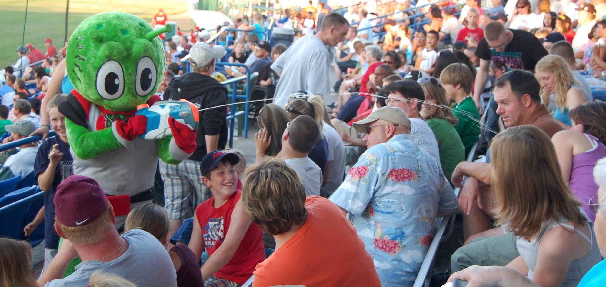 Orbit, Great Falls Voyagers mascot, shoots a fan with a water gun during Military Appreciation Night July 18 at Centene Stadium. (U.S. Air Force photo/Airman 1st Class Dillon White)