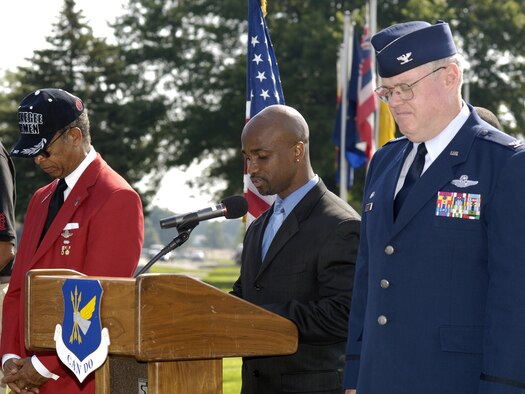MCGUIRE AIR FORCE BASE, NJ - Col. James L. Kerr, 514th Air Mobility Wing Commander (right) stands on stage with Lt. Gen. (Ret) Russell Davis, Tuskegee Airmen, Inc. (left) while Titus Welcome, a civilian with 305 AWM (center) gives the invocation for the rededication ceremony of Tuskegee Airmen Avenue on McGuire Air Force Base. The ceremony was to recognize and honor the accomplishments and bravery of the Tuskegee Airmen in World War II. The ceremony was the first official event of the Tuskegee Airmen's 37th annual convention held in Philadelphia July 17 to 20. Col. Kerr opened the ceremony with his remarks and  Lt. Gen. (Ret) Davis gave the keynote speech. Afterwards they assisted with the unveiling of a new street sign featuring the Congressional Gold Medal in recognition of the Tuskegee Airmen's award received in March 2007. Tuskegee Airmen, Incorporated is a national organization that works to honor the accomplishments and perpetuate the history of the enlisted African-American men who enlisted during World War II to become America's first black military Airmen, ground crew and mechanics. They succeeded in their missions despite the challenges of racial discrimination. (U.S. Air Force Photo/ Mr. Kenneth Mann)