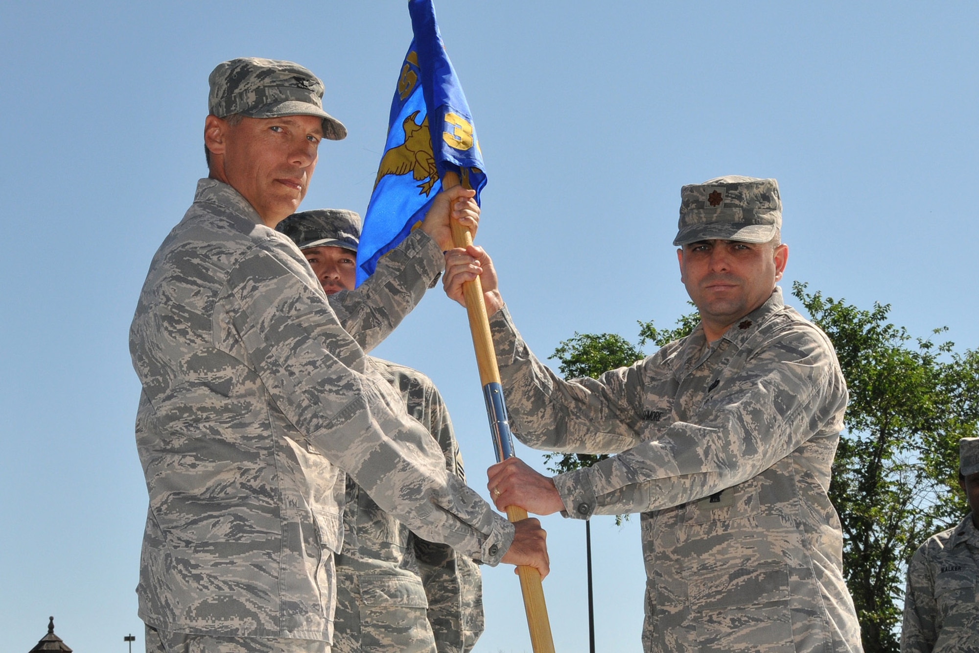 Maj. Charles Ashmore, accepts command of the newly formed 341st Force Support Squadron from Col. Roderick Davis, 341st Mission Support Group commander, during a merger ceremony July 17. The 341st Mission Support and 341st Services Squadrons combined to form the new 341st FSS. Master Sgt. Keith Vivian, 341st FSS first sergeant, looks on. (U.S. Air Force photo/John Turner)