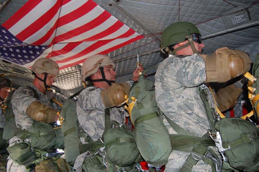 Members of the 819th RED HORSE Squadron airborne team performed jump training at Malmstrom Air Force Base with aerial assistance from the Montana Army National Guard and their Chinook helicopter July 23. Teammates receive orders to prepare for the jump and tether onto the jump line once the helicopter reached 1,500 feet altitude. The parachutes weigh about 40 pounds each and their backpacks and gear weigh between 60 to 75 pounds. (U.S. Air Force photo/Senior Airman Eydie Sakura)