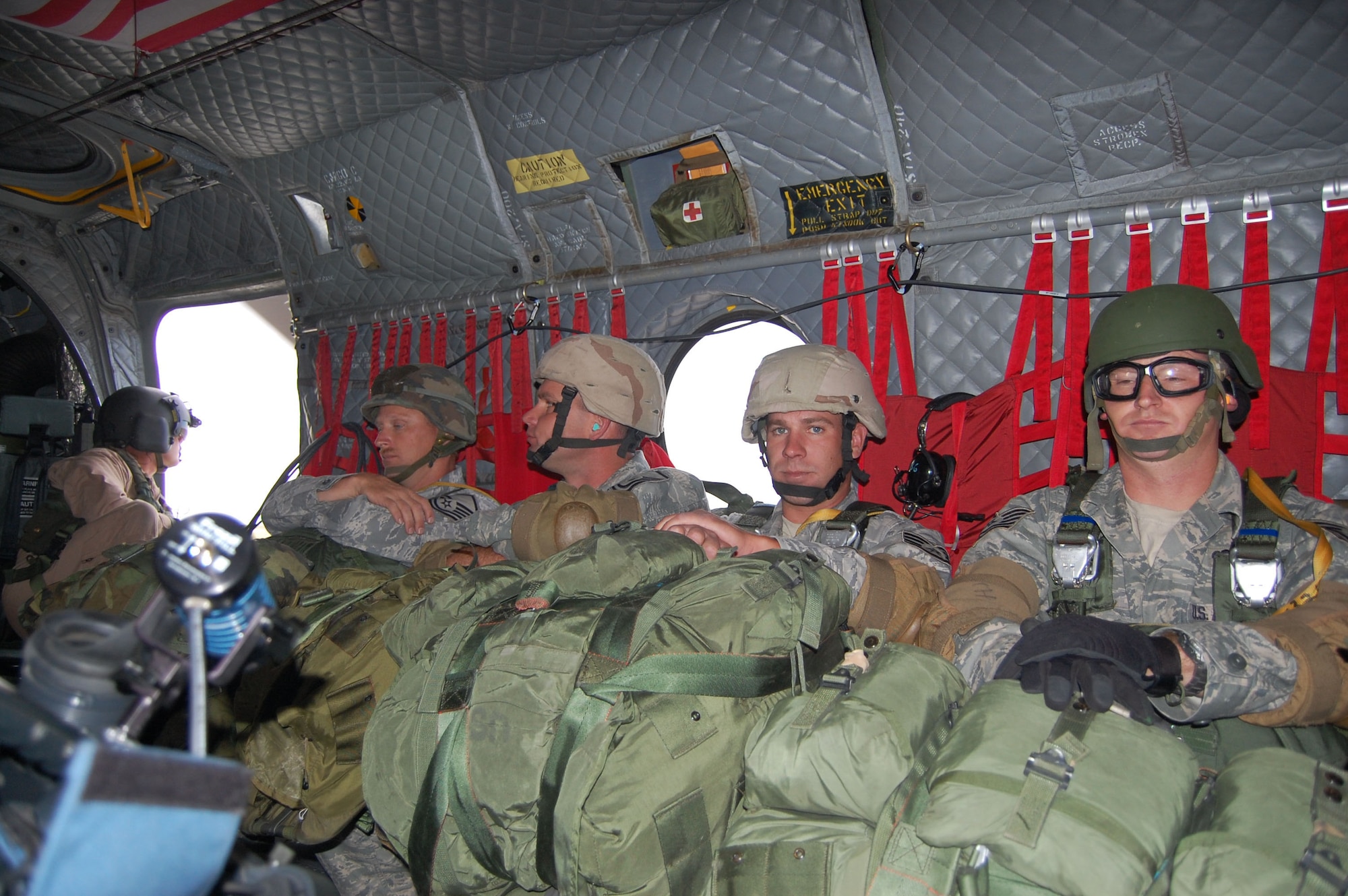 Members of the 819th RED HORSE Squadron airborne team performed jump training at Malmstrom Air Force Base with aerial assistance from the Montana Army National Guard and their Chinook helicopter July 23. The Airmen await orders to jump while the helicopter gains altitude of roughly 1,500 feet. The parachutes weigh about 40 pounds each and their backpacks and gear weigh between 60 to 75 pounds. (U.S. Air Force photo/Senior Airman Eydie Sakura)
