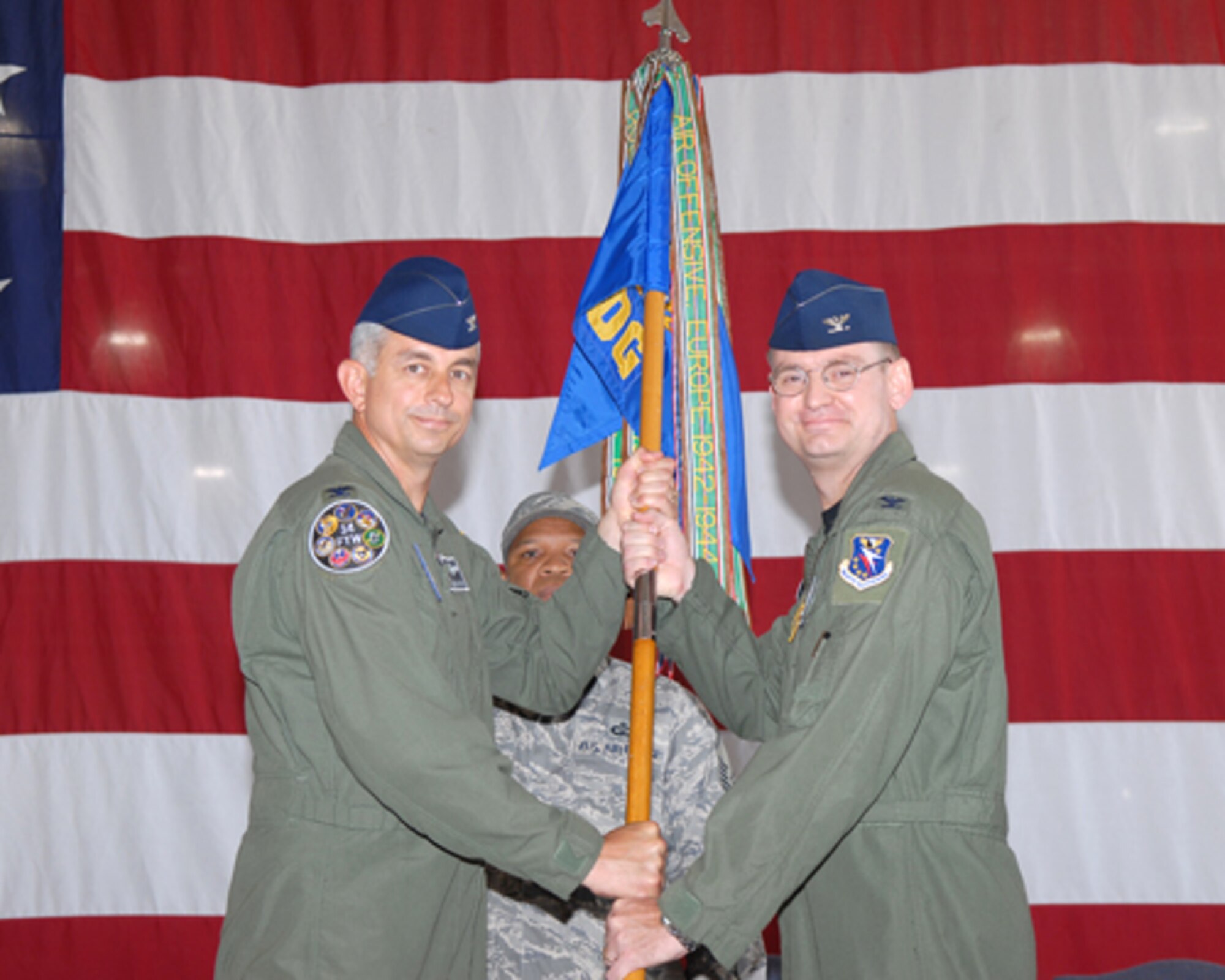 Colonel Roger Watkins, 14th Flying Training Wing commander, presents Col. David Reth the 14th Operations Group guidon upon assuming command of the 14th OG in a ceremony held in Hangar 6, the Louis C. Malloy Hangar Wednesday. Colonel Reth was previously the deputy commander of USAFE Detachment 5 Operating Location – Alpha at Ramstein AB, Germany. (U.S. Air Force photo by Melissa Duncan)