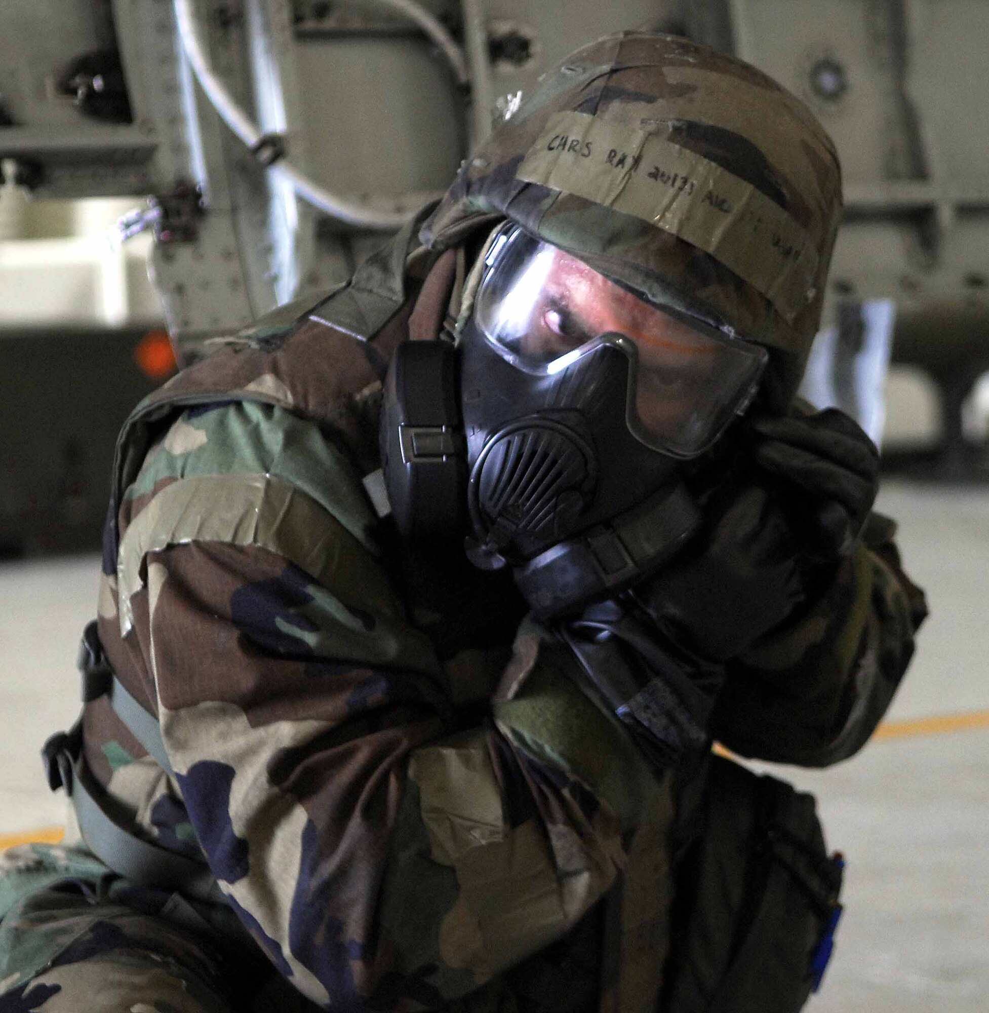 OSAN AIR BASE, Republic of Korea – Airman 1st Class Chris Ray, 51st Aircraft Maintenance Squadron, dons his M-50 protective mask and secures his helmet during an exercise here July 22. Airman Ray is an aircraft armament systems specialist. (U.S. Air Force photo/Senior Airman Christopher Boitz)