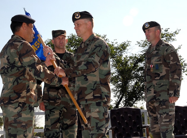 Col. Steve Asher, 341st Security Forces Group commander, hands over the guidon to the 741st Missile Security Squadron to Maj. Warren Brainard in a change of command ceremony July 17. Outgoing 741st MSFS commander, Lt. Col. Raymund Tembreull, looks on. (U.S. Air Force photo/John Turner)