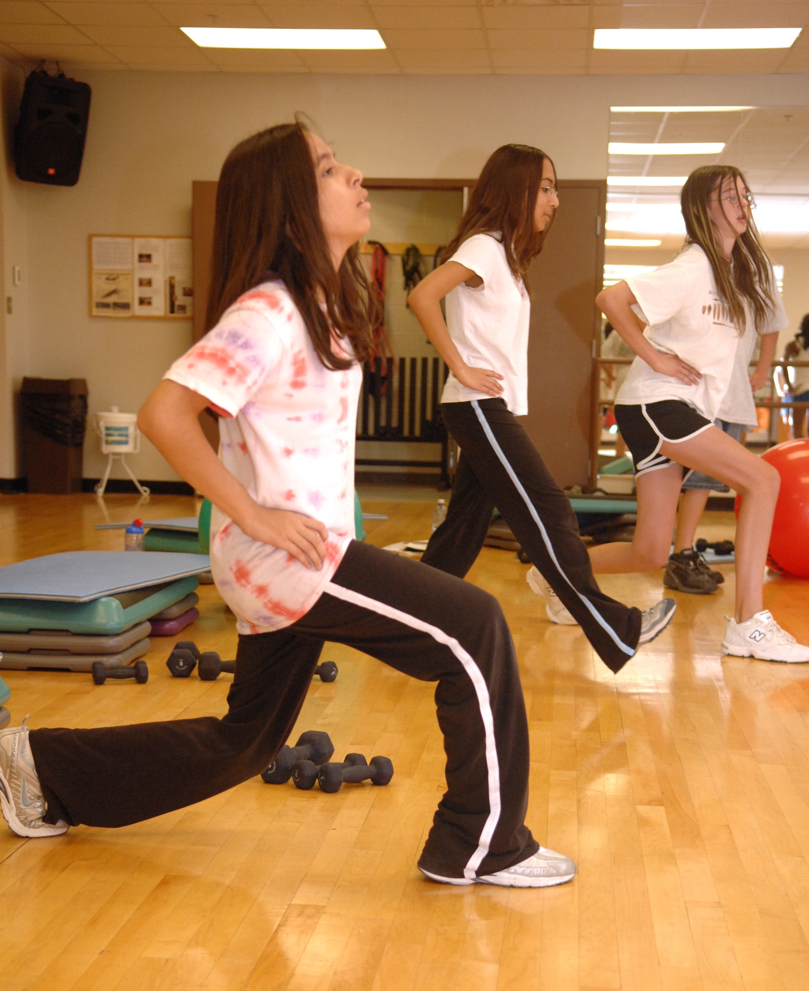 Holloman teenagers, Monica Harris, Miranda Garcia and Victoria Garcia, do lunges during a body sculpting class at the Fitness and Sports Center at Holloman Air Force Base, N.M., July 23. The class was part of the two-day Teen Wellness and Fitness Camp and was taught by Tech. Sgt. Joya Stotz of the 49th Force Support Squadron. (U.S. Air Force photo/Airman Sondra M. Wieseler)