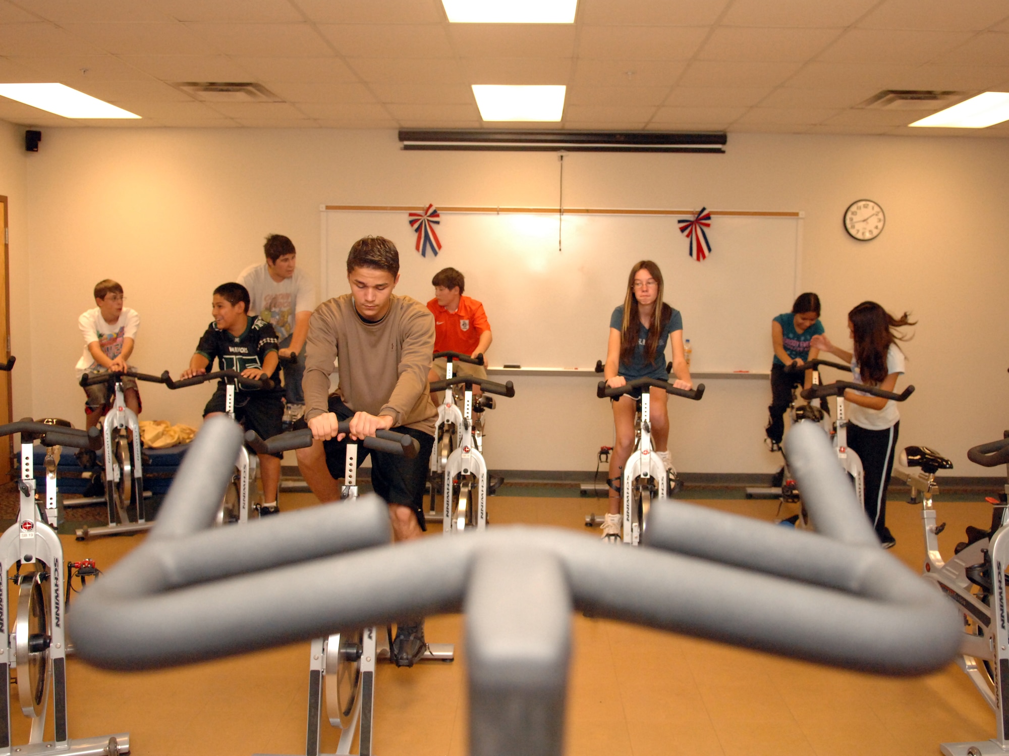 Teenagers aged 13 ? 18 participate in a spin class hosted by Airman 1st Class Amanda Morgan, 49th Force Support Squadron, at the Fitness and Sports Center at Holloman Air Force Base, N.M., July 21. The teenagers are enrolled in a two-day Teen Wellness and Fitness Camp to help them understand the fundamentals of fitness, proper eating and a healthy lifestyle. (U.S. Air Force photo/Airman Sondra M. Wieseler)