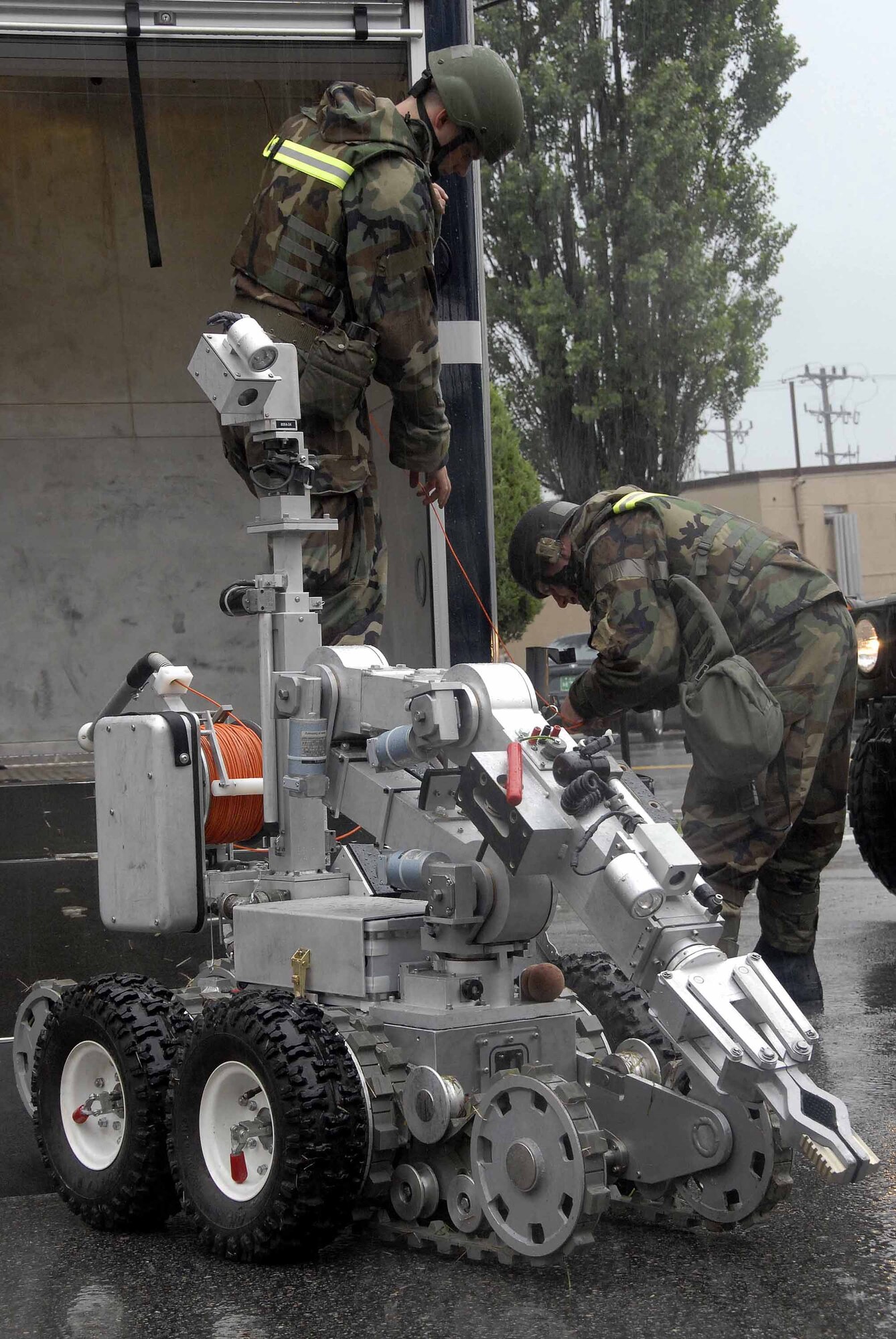 OSAN AIR BASE, Republic of Korea -- Airman Matthew Morris, (left), and Tech. Sgt Jared Worstell, guide the F6A robot as it prepares to remove a suspicious package from the base post office during a base-wide exercise here July 24. Both Airmen are 51st Civil Engineer Squadron explosive ordinance disposal technicians. (U.S. Air Force photo/Staff Sgt. Lakisha Croley)