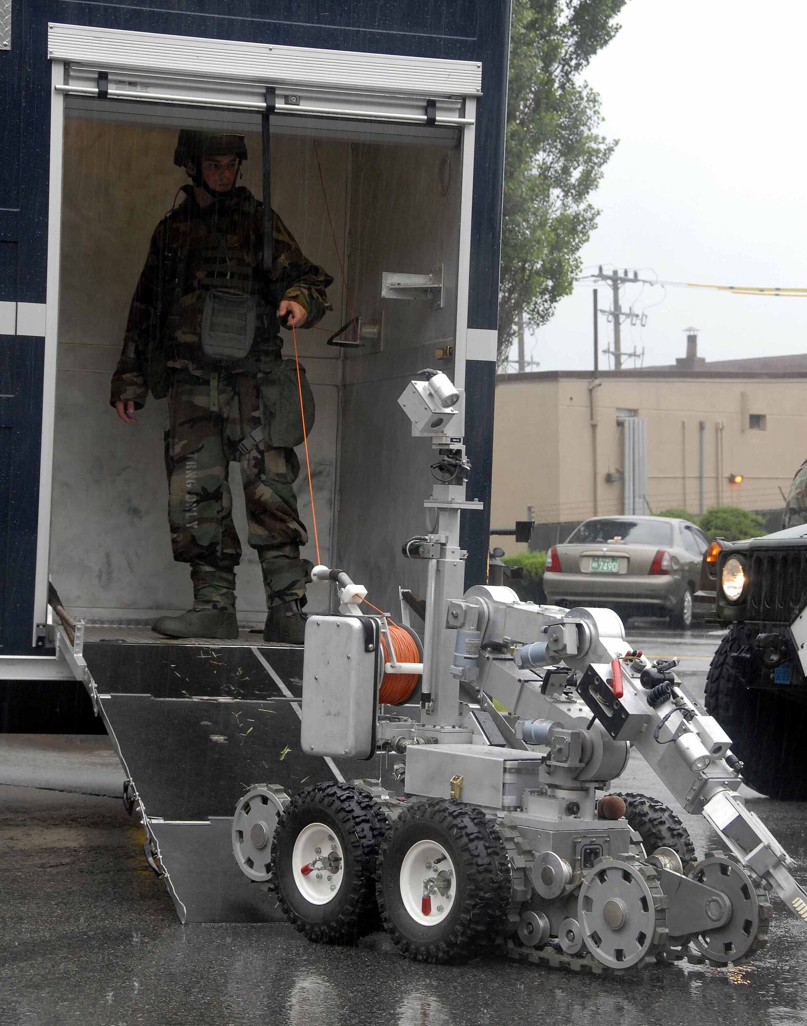 OSAN AIR BASE, Republic of Korea -- Airman Matthew Morris, 51st Civil Engineer Squadron explosive ordinance disposal apprentice, guides the F6A robot as it prepares to remove a suspicious package from the base post office during a base-wide exercise here July 24. The F6A is equipped with several television cameras for remote viewing and a dexterous arm for hazardous tasks. (U.S. Air Force photo/Staff Sgt. Lakisha Croley)
