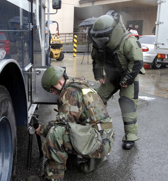 OSAN AIR BASE, Republic of Korea -- Airman Matthew Morris, (left), prepares Tech. Sgt Jared Worstell to accompany the F6A robot to remove a suspicious package from the base post office during a base-wide exercise here July 24. The F6A is equipped with several television cameras for remote viewing and a dexterous arm for hazardous tasks. Both Airmen are 51st Civil Engineer Squadron explosive ordinance disposal technicians. (U.S. Air Force photo/Staff Sgt. Lakisha Croley)