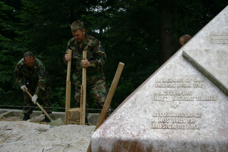 Master Sgt. Robert A. Gordon and Tech. Sgt. Shaun Blische, both members of the 175th Civil Engineer Squadron, restore a monument at Mount Igman, Bosnia-Herzegovina. The monument memorializes three American diplomats and their French driver, who were killed at the site in 1995. The memorial is being restored by members of the Maryland National Guard as part of a humanitarian civic action project under the auspices of the National Guard’s State Partnership Program. (U.S. Air Force photo by Tech. Sgt. David D. Speicher)