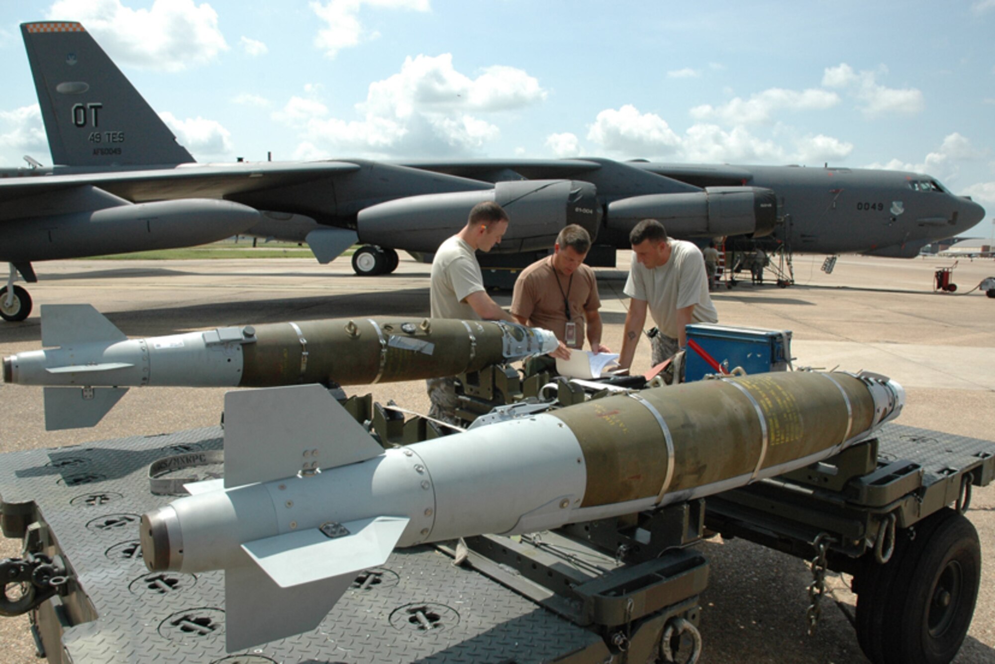 Staff Sgt. John Robertson, Tech Sgt. Allan Weigold, 49th Test and Evaluation Squadron, and Staff Sgt. Norman Startzel, 2nd Bomb Wing, plan their movements before loading two Laser Joint Direct Attack Munitions onto a B-52 from the 49th Test and Evaluation Squadron at Barksdale Air Force Base, La., July 10. The 49th TES demonstrated the B-52's LJDAM capability on a target on the after a cross country flight. The target was stationary, but the 49th plans to demonstrate the LJDAM on a moving target soon. The laser piece of the munition allows for updated targeting and adjustments to moving targets. Photo by Boeing. 