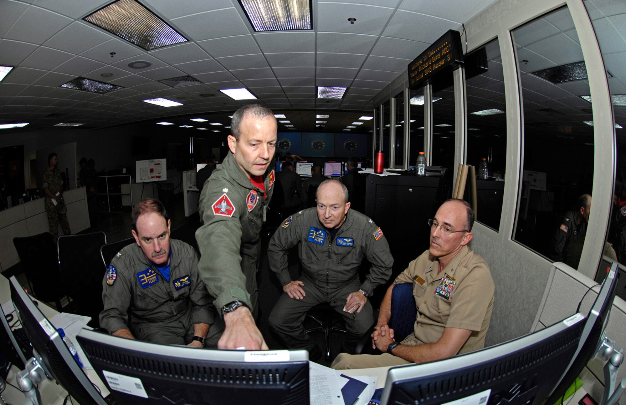 Navy Capt. Paul Innis, Navy Cmdr. David Little, Navy Capt. Chris Sprinkle and Navy Cmdr. Doug Anderson discuss a battle strategy in the 613th Air and Space Operations Center July 22 at Hickam Air Force Base, Hawaii. The officers are providing command and control for the airpower in Exercise Rim of the Pacific 2008. (US Air Force photo/Master Sgt. Chris Vadnais) 
