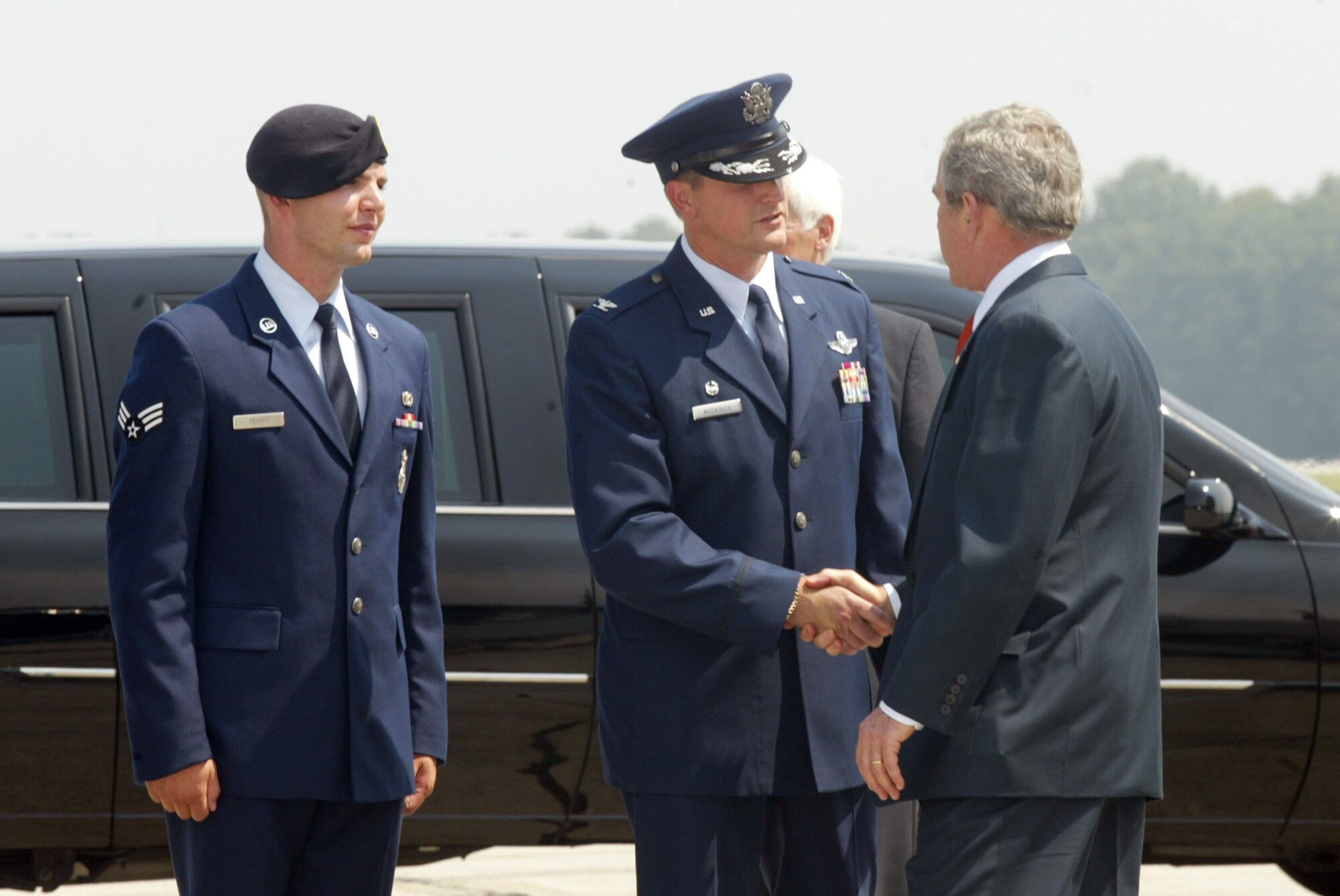 President George W. Bush greets Col. Heath Nuckolls, 94th Airlift Wing commander, and Senior Airman Alan Perry, 94th Security Forces Squadron.  President Bush landed at Dobbins Air Reserve Base on Tuesday, Aug. 22 en route to a private event in Atlanta. (U.S. Air Force photo/Don Peek)