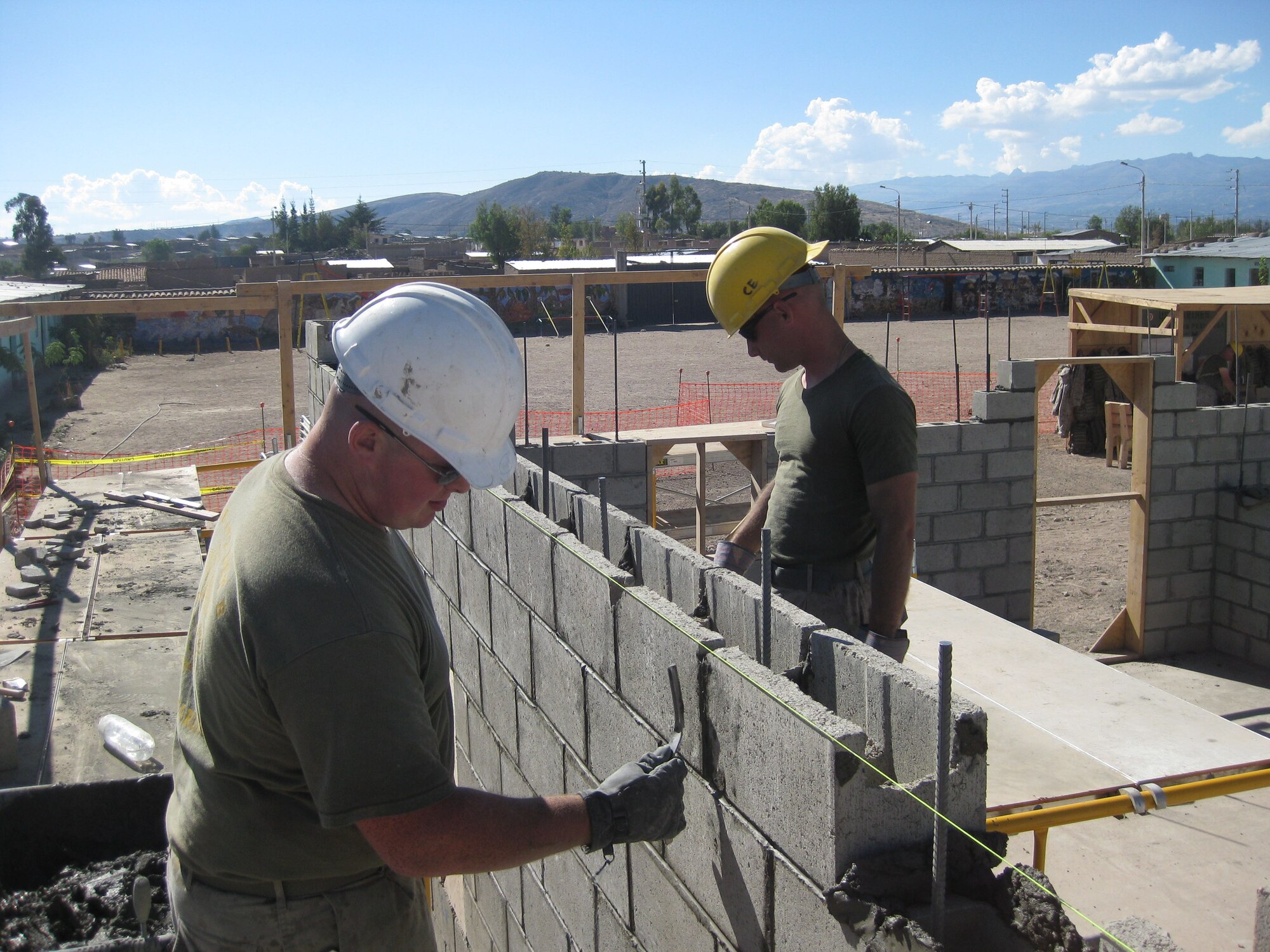 Lance Cpl. James Phelan, left, and Sgt. Jason Beall strike joints while constructing a schoolhouse in Yanamilla, Peru, July 1, during New Horizons - Peru 2008, a U.S. and Peruvian partnered humanitarian mission to bring reflief to the Ayacucho region of Peru. (U.S. Marine photo/Cpl. Kathleen Ruscio)