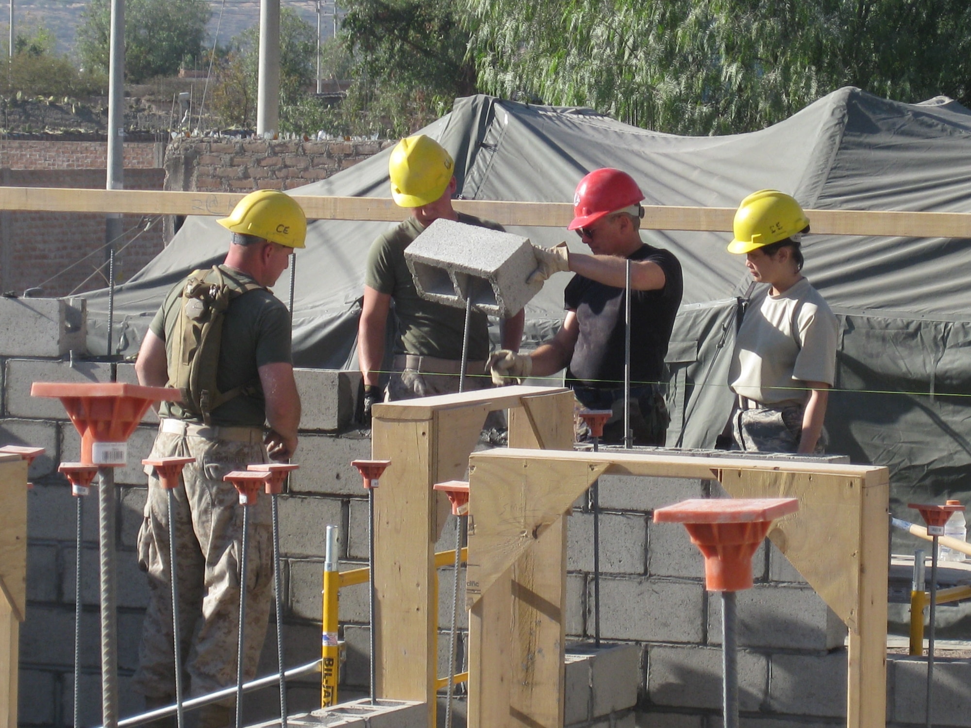 Left to right, Cpl. Corey Lameroux, Lance Cpl. Kristopher Osborne, Maj. James Glass and Staff Sgt. Romeriza Miguel lay block as part of the construction process for a medical clinic in Yanamilla, Peru, June 25.  The Marine Wing Support Squadron 472 is participating in New Horizons - Peru 2008, a U.S. and Peruvian partnered humanitarian mission to bring relief to the Ayacucho region of Peru. (U.S. Marine photo/Cpl. Kathleen Ruscio)