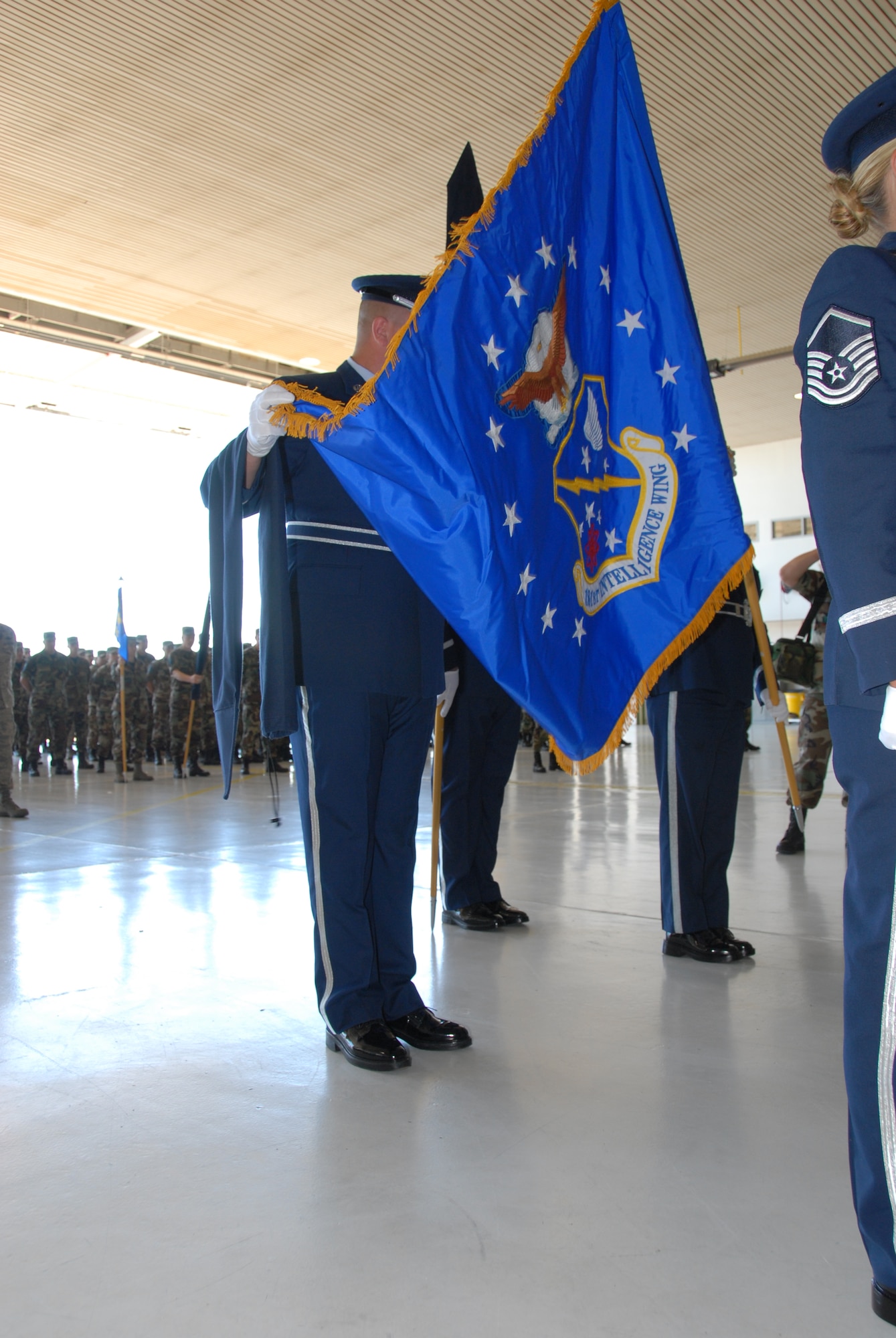 The 181st Fighter Wing, Terre Haute, Ind., conducted a redesignation ceremony on 13 July, 2008 officially marking its transition from flying jets to processing intelligence and providing ground support to air operations at forward locations. Honor guard members unfurl new unit flag. U.S. Air force photo by TSgt Michael W. Kellams.