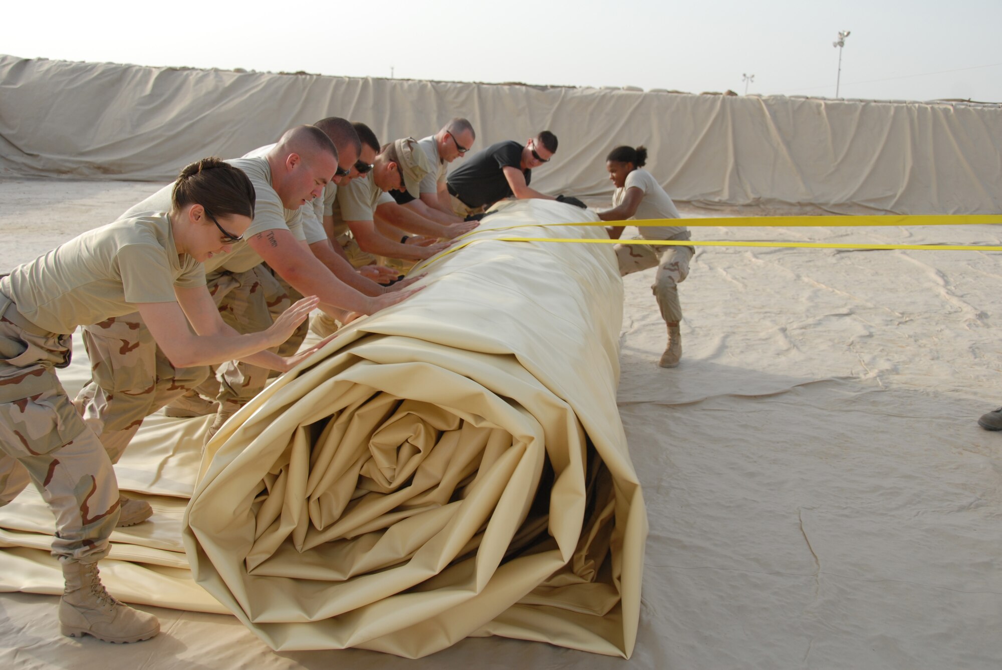 Lt. Col. Tanya Kubinec, Commander of the 380th Expeditionary Logistics Readiness Squadron, works with her troops to roll out a new fuel bladder. The fuel bladder weighs approximately 2.5 tons empty and it can hold 200,000 gallons of fuel. ELRS changed out the bladder due to normal wear and tear and climate conditions.(U.S. Air Force photo/Tech. Sgt. Christopher A Campbell)