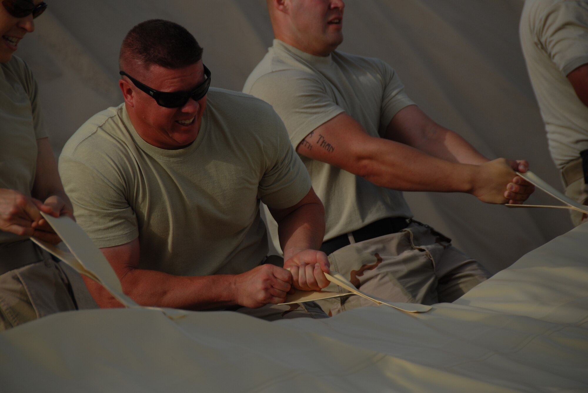 Senior Master Sgt. Troy Schafer, a member of the 380 Expeditionary Logistics Readiness Squadron shows how much energy is needed to spread out a new fuel bladder. The fuel bladder weighs approximately 2.5 tons empty and it can hold 200,000 gallons of fuel. ELRS changed out the bladder due to normal wear and tear and climate conditions. Sergeant Schafer is deployed from the 28th LRS located at Ellsworth AFB S.D..(U.S. Air Force photo/Tech. Sgt. Christopher A Campbell)