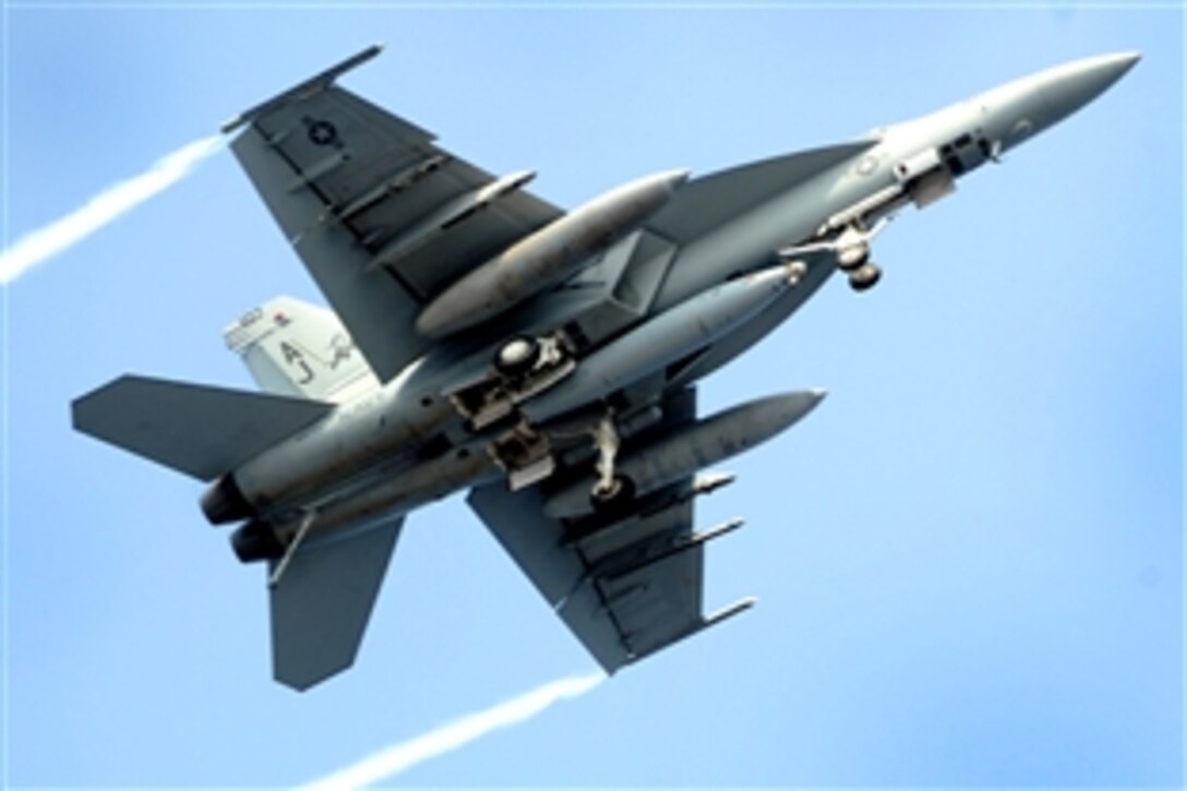 A U.S. Navy F/A-18 Super Hornet flies over the Nimitz-class aircraft carrier USS Theodore Roosevelt in the Atlantic Ocean, July 22, 2008. The Theodore Roosevelt Carrier Strike Group is participating in Joint Task Force Exercise "Operation Brimstone" off the Atlantic coast.