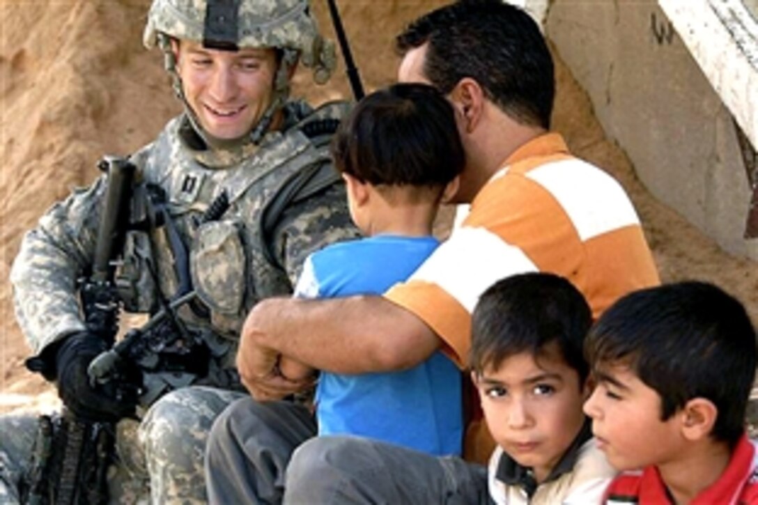 U.S. Army Cpt. Michael Kolton stops to speak with a local man during a combined dismounted patrol with Iraqi police officers in the Ghazaliya district, Baghdad, Iraq, July 18, 2008. Kolton, a platoon leader, is assigned to the 101st Airborne Division's Bravo Troop, 75th Cavalry.
