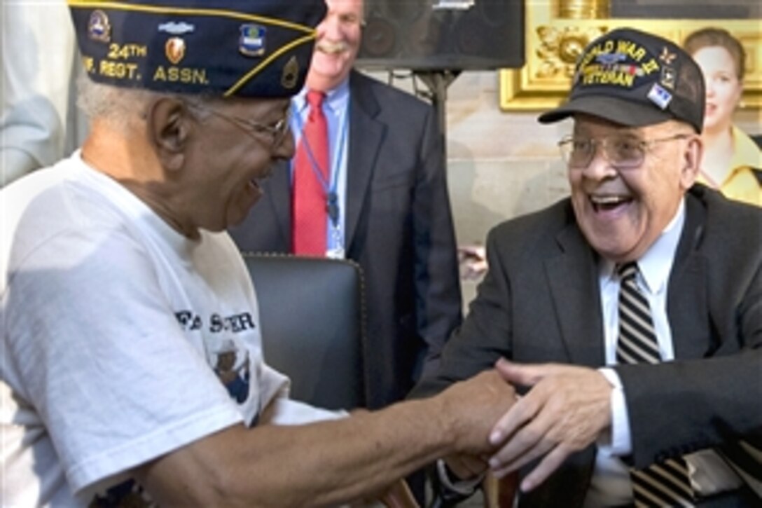 World War II veteran Spencer Moore, right, greets a fellow African-American former soldier at the conclusion of the ceremony to mark the 60th anniversary of the integration of the armed forces in the Capitol Rotunda, Washington, D.C., July 23, 2008.  