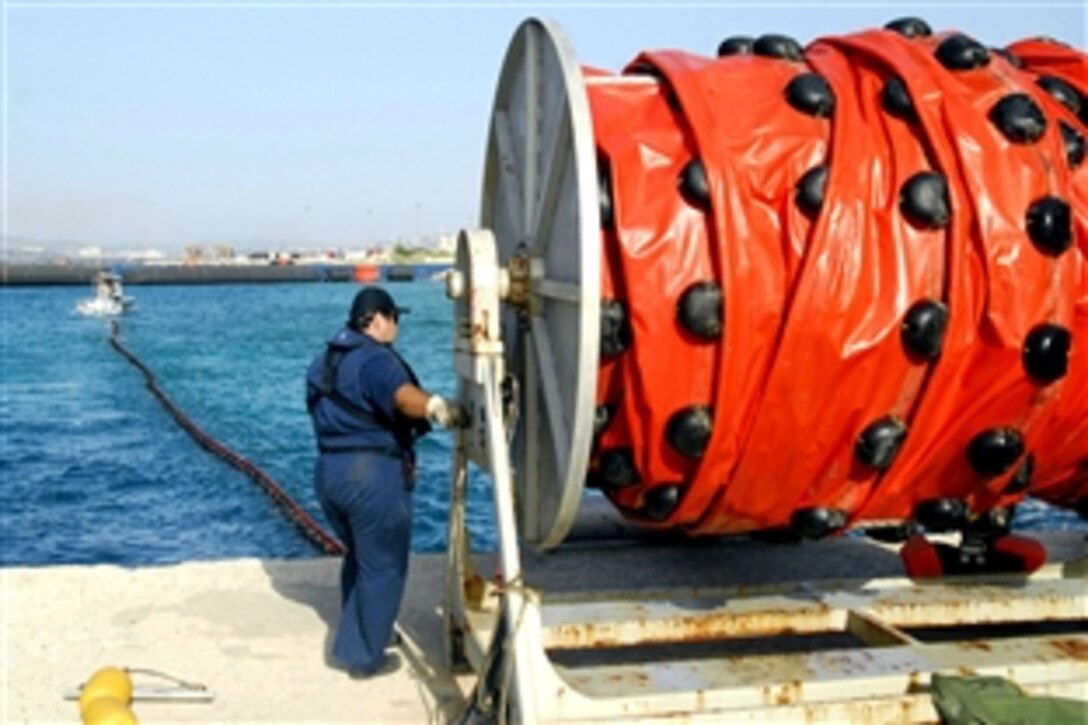 A civilian employee assigned to U.S. Naval Support Activity Souda Bay Port Operations deploys a hydraulic-powered boom reel during a drill to test procedures to contain and recover oil during a spill, Crete, Greece, July 23, 2008.