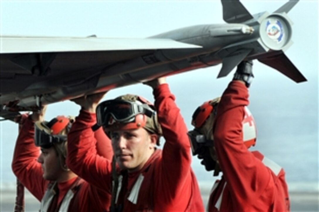 U.S. Navy aviation ordnancemen assigned to the "Blue Blasters" of Strike Fighter Squadron 34 wait to arm weapons as an F/A-18C Hornet is prepared for a mission aboard the aircraft carrier USS Abraham Lincoln in the North Arabian Sea, July 23, 2008. The Lincoln is deployed to the U.S. 5th Fleet area of responsibility supporting Operation Iraqi Freedom and Operation Enduring Freedom.
