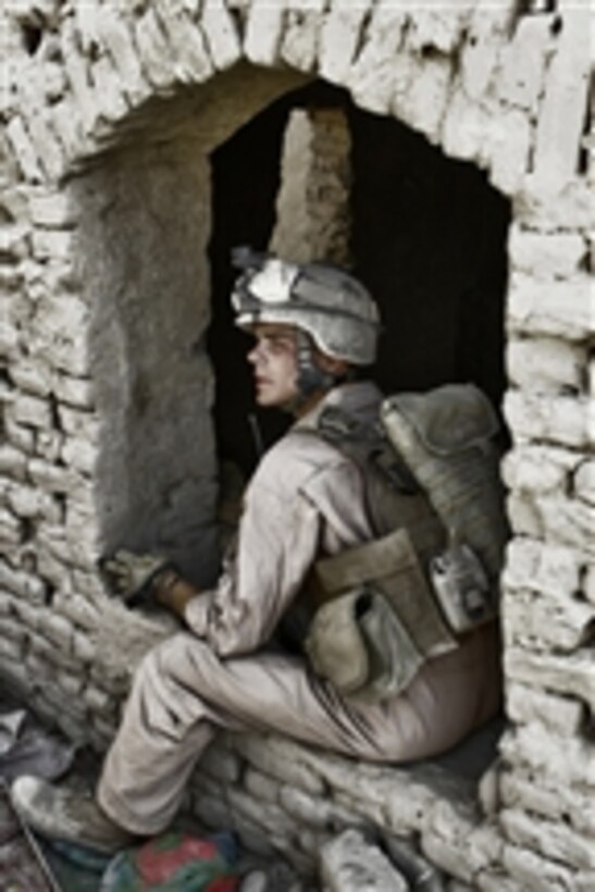 U.S. Marine Corps Sgt. Justin Goeden, a squad leader assigned to 1st Platoon, Bravo Company, Battalion Landing Team, 1st Battalion, 6th Marine Regiment, 24th Marine Expeditionary Unit, NATO, International Security Assistance Force sits in the open window of a building during a patrol in the Helmand province of Afghanistan on July 1, 2008.  