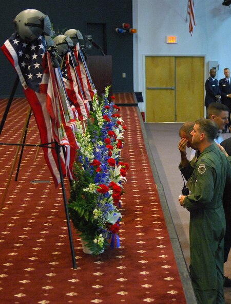 BARKSDALE AFB, La -- Lt Col. Jeffrey Vandenbushce, 11th Bomb Squadron Commander, consoles a fellow Airman during the memorial service for Maj. Christopher Cooper, Maj. Brent Williams, Capt. Michael Dodson, 1st Lt. Robert Gerren and 1st Lt. Joshua Shepherd at Hoban Hall on July 25, 2008. A sixth officer stationed at Andersen Air Force Base, Guam, was also part of the fallen crew referred to as Raider 21. (USAF Photo by Staff Sgt. Trina R. Jeanjacques)(Released)